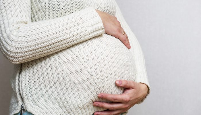 bigstock-Pregnant-Woman-Holds-Hands-On-391395944.jpg