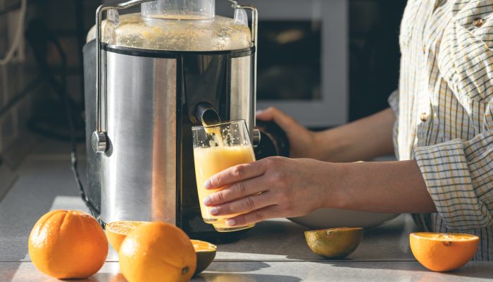 woman-makes-orange-juice-home-kitchen-with-electric-juicer.jpg