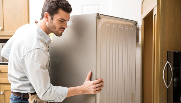 young-man-working-as-electrician-exposing-back-fridge-check-repair-it-1.jpg